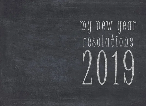 Concept of New Year resolution fading, being erased, forgotten or falling apart - white chalk handwriting on blackboard