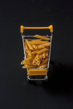 Penne (pasta) in the shopping cart to represent a concept clipart