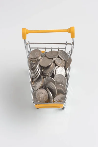 Coins in the shopping cart on a white background — Stock Photo, Image