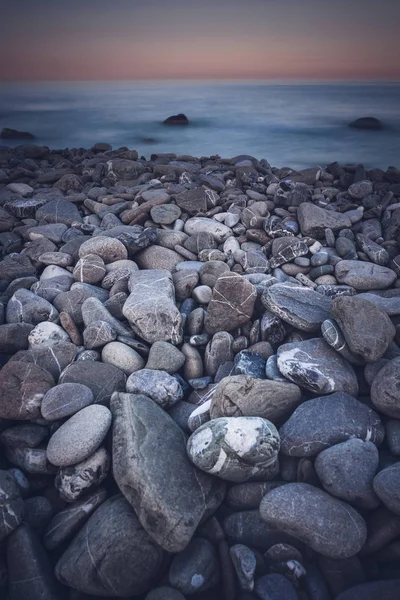 Rots zee kust met zwarte ronde steen op het eiland — Stockfoto