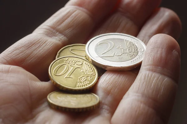 A man counts coins in his hand — Stock Photo, Image