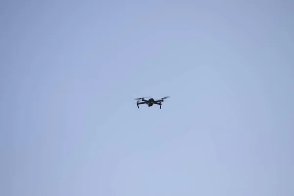 Drone quadcopter with camera against the blue sky