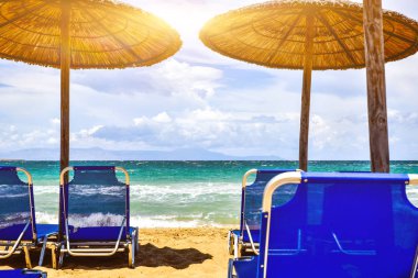 Güneş şezlong ve plaj şemsiyesi mavi su dalgalar deniz