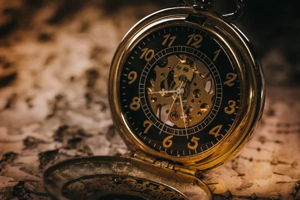 Vintage grunge still life with pocket watch. Selective focus in the middle of pocket watch