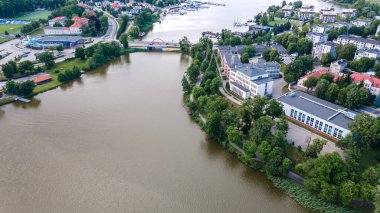 Polonya 'nın Ilawa kasabasındaki İHA' dan alınan farklı fotoğrafların karışımında bir kilise, Jeziorak Gölü, ev mülkü, yüzme havuzu, amfi tiyatro, demiryolu deposu, yelken limanı, orman adası, hastane vb..