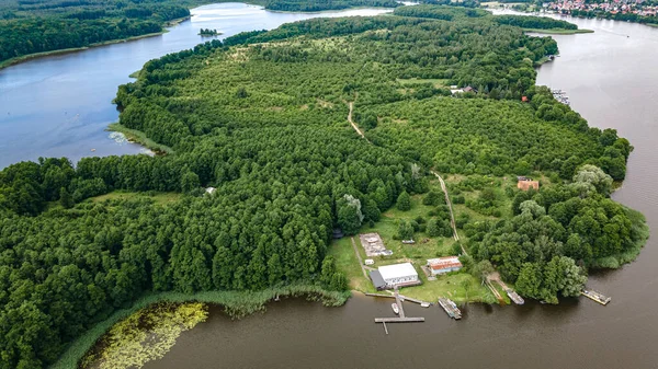 The mix of different photos taken from drone in Ilawa town in Poland, there is a church, lake Jeziorak, house estate, swimming pool, amphitheater, railway depot, sailing harbor, forest island, hospital etc.