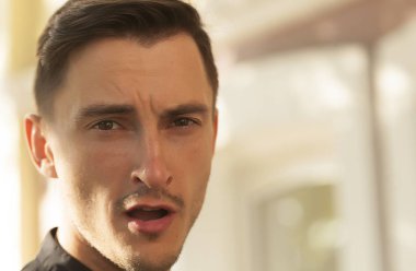 ciddi bir genç adam portresi. Genç brunet erkek merak ettim, duygu, konsantrasyon ve gerginlik, Genç adam kameraya, ciddi göz arıyorum