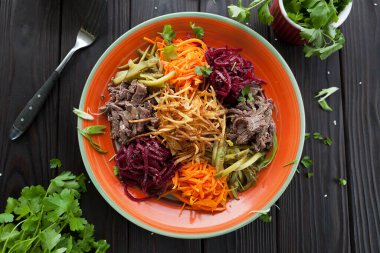 Parlak tabakta sığır etli sebze salatası, koyu ahşap masada gurme öğle yemeği, parlak Asya yemeği.