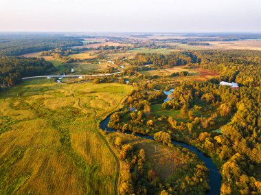 Sonbahar kırsal havadan görünümü meadows, nehir, Köyü, toprak yol ve tarım alanları ile arka plan üzerinde. Yukarıdan günbatımı sonbahar sahne