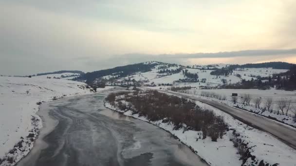 早春の雪や氷を溶かします 凍結する冬の川 道路の空中の田舎の風景 — ストック動画