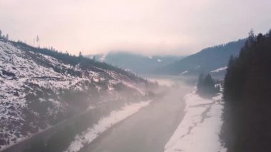 Sisli donmuş kış nehir. Hava kırsal manzara karlı Köyü ve yol. Erken ilkbaharda eriyen kar ve buz. Karpat Dağları, Ukrayna'da Beskidy aralığı