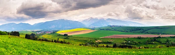 Tempestade de primavera no panorama das montanhas. Prado de dente de leão . — Fotografia de Stock