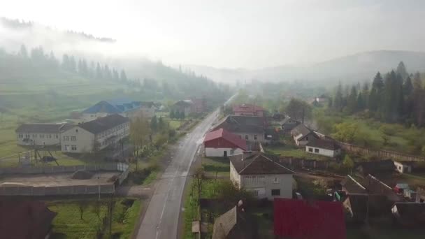 Road in mountain village. Rural spring misty landscape. Aerial Panorama of Carpathian valley. — Stock Footage Road Mountain Village Rural Spring Misty Landscape Aerial Panorama Carpathian Royalty Free Stock Footage