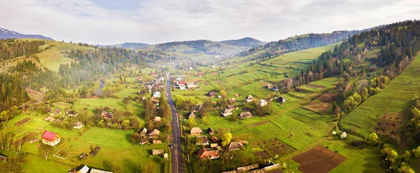 Droga w górskiej wiosce. Panorama lotnicza doliny karpackich. — Zdjęcie stockowe