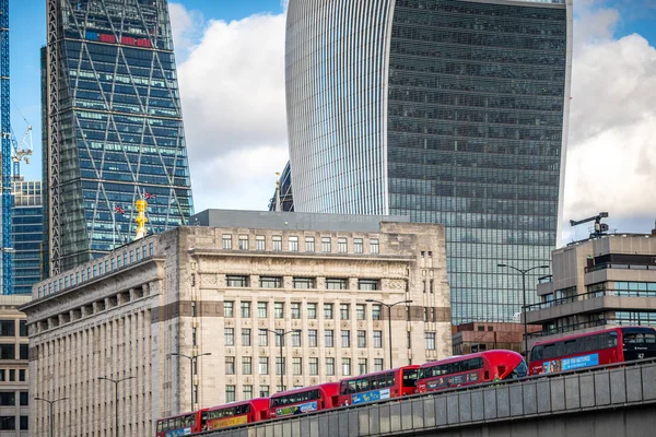 NOVEMBER 13, 2018, London, United Kingdom : Iconic new red London double decker passenger buses on London Bridge feat. Famous Office Buildings