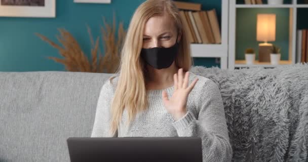 Charmante Dame in Maske mit Videoanruf auf Laptop — Stockvideo