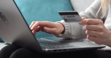 Çevrimiçi alışveriş için dizüstü bilgisayar ve kredi kartı kullanan kadın