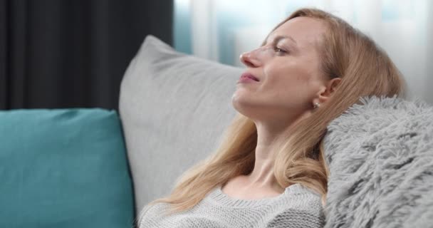 Charmante femme se détendre sur le canapé avec un verre de vin — Video