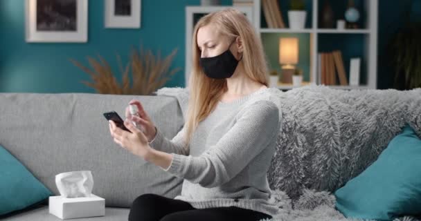 Reife Frau desinfiziert Smartphone mit Antiseptikum — Stockvideo