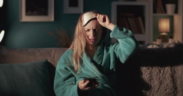 Sleepy woman in bathrobe using smartphone at morning time — Stock Video