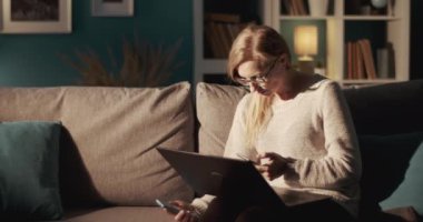 Uzaktan kumandalı bilgisayar ve akıllı telefonla çalışan ciddi bir kadın.