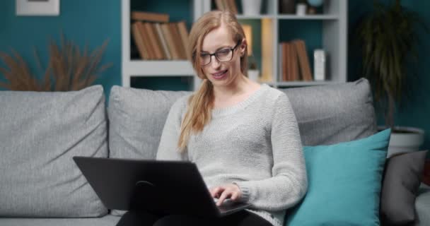 Hermosa dama en gafas teniendo conversación en línea en casa — Vídeos de Stock