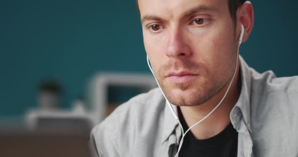 Close up of male worker in earphones using laptop — 图库视频影像