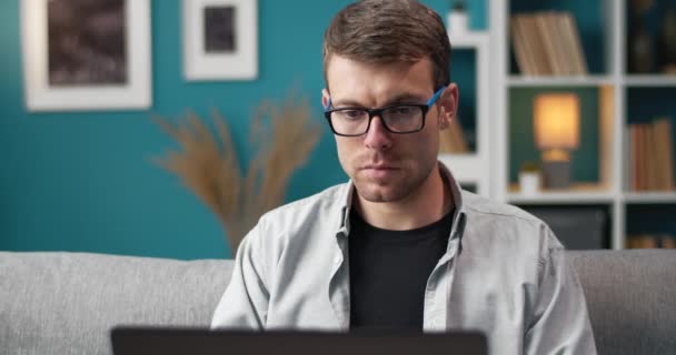 Estudiante masculino usando portátil para estudiar en línea en casa — Vídeo de stock