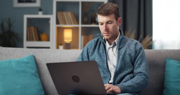 Bearded worker using personal laptop while sitting at home — Αρχείο Βίντεο