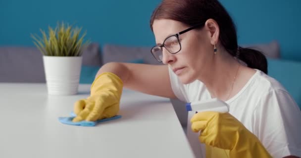 Домохозяйка вытирает пыль о деревянный стол синей тряпкой — стоковое видео
