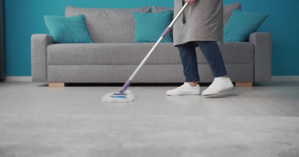 Housewife using swabber for washing floor at living room — 비디오