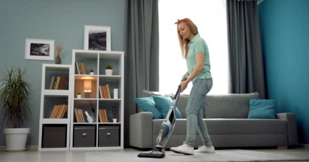 Beautiful woman using vacuum cleaner for white carpet — Stock Video