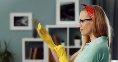 Ev hanımı temizlik yapmadan önce koruyucu eldiven takıyor.