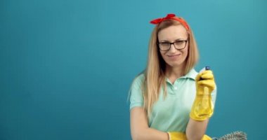 Kadın kamerada temizlik spreyi ve fırçasıyla poz veriyor.