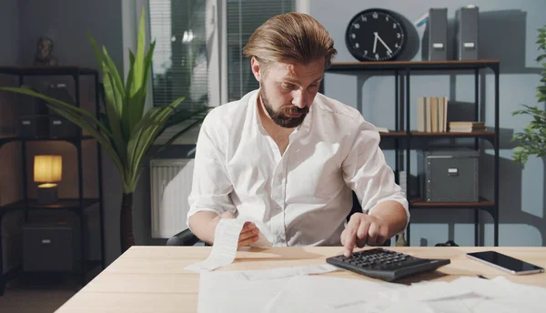 İş adamı hesap makinesinde numaraları kontrol ediyor