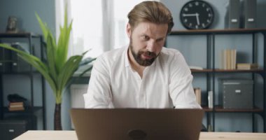 Sakallı adam laptopta iş görüşmesi yapıyor.