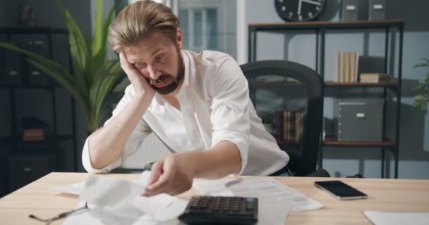 Homme d'affaires déçu vérifier les factures au bureau moderne — Video