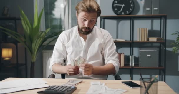 Triste hombre de negocios contando dinero según facturas — Vídeo de stock