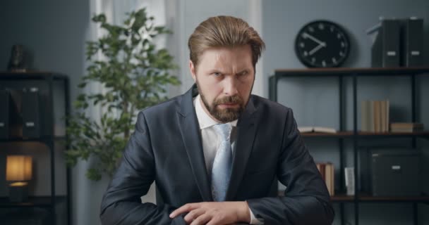 Homem irritado sentado no escritório e gesticulando com indicador — Vídeo de Stock