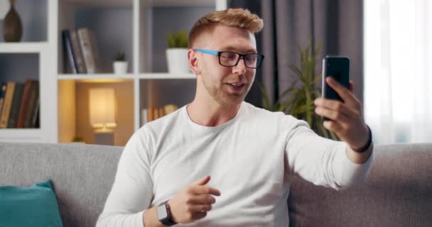 Happy guy met behulp van smartphone voor video chat thuis — Stockvideo