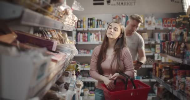 Personas que usan cesta mientras compran productos en el supermercado — Vídeos de Stock