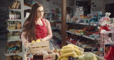 Kadın danışman erkeğin taze meyve almasına yardım ediyor.