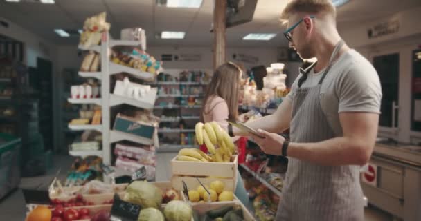 Homem de preenchimento de banco de dados em tablet sobre frutas orgânicas frescas — Vídeo de Stock