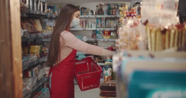 Female manager in mask and gloves arranging goods at store — Stock Video