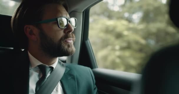 Pria berjenggot berjas hitam raja melalui jendela mobil yang bergerak — Stok Video