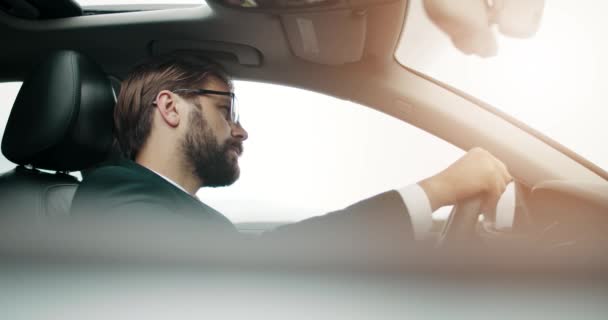 Vista lateral del exitoso hombre de negocios conduciendo con seguridad propio coche — Vídeo de stock