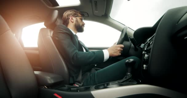 Conductor masculino experimentado en traje que conduce atentamente el coche — Vídeo de stock