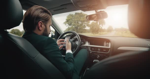 穿黑色西服的男人在车里用智能手机给GPS导航 — 图库视频影像