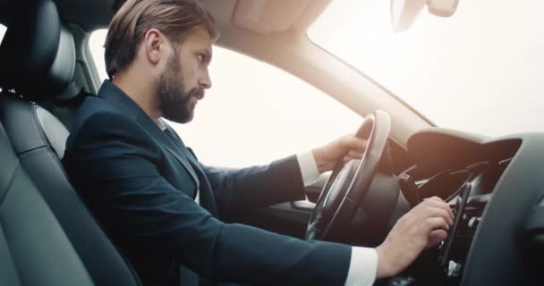 Hombre barbudo enfocado usando navegación GPS en auto — Vídeos de Stock
