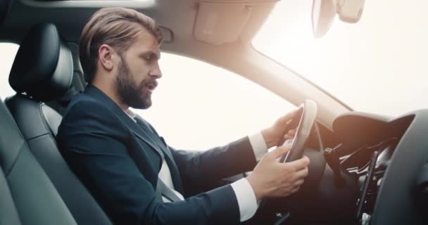 Empresário dirigindo carro e usando alto-falante no smartphone — Vídeo de Stock